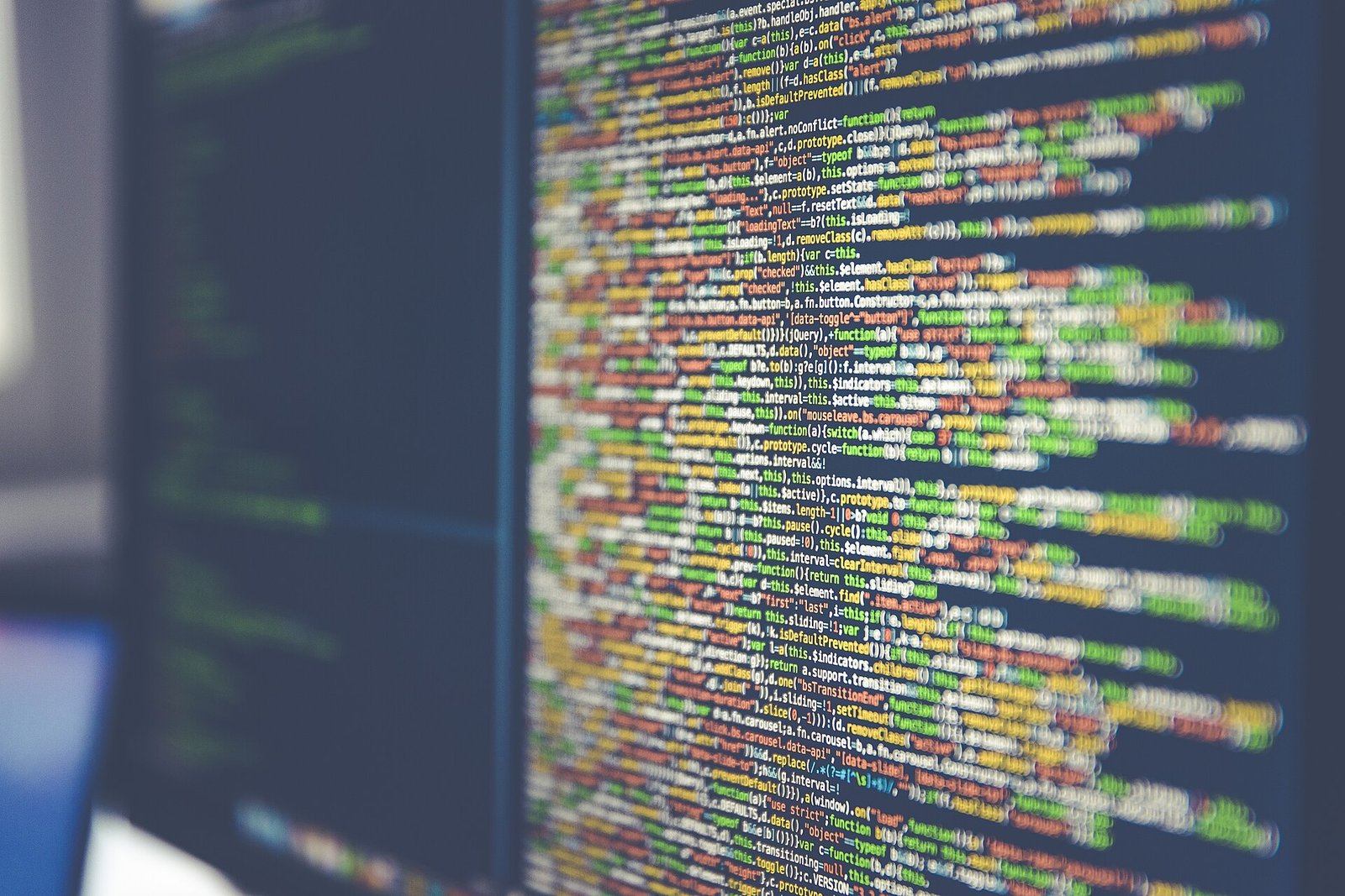 Illustrative image of lines of colorful programming code on a computer monitor, shown out of focus