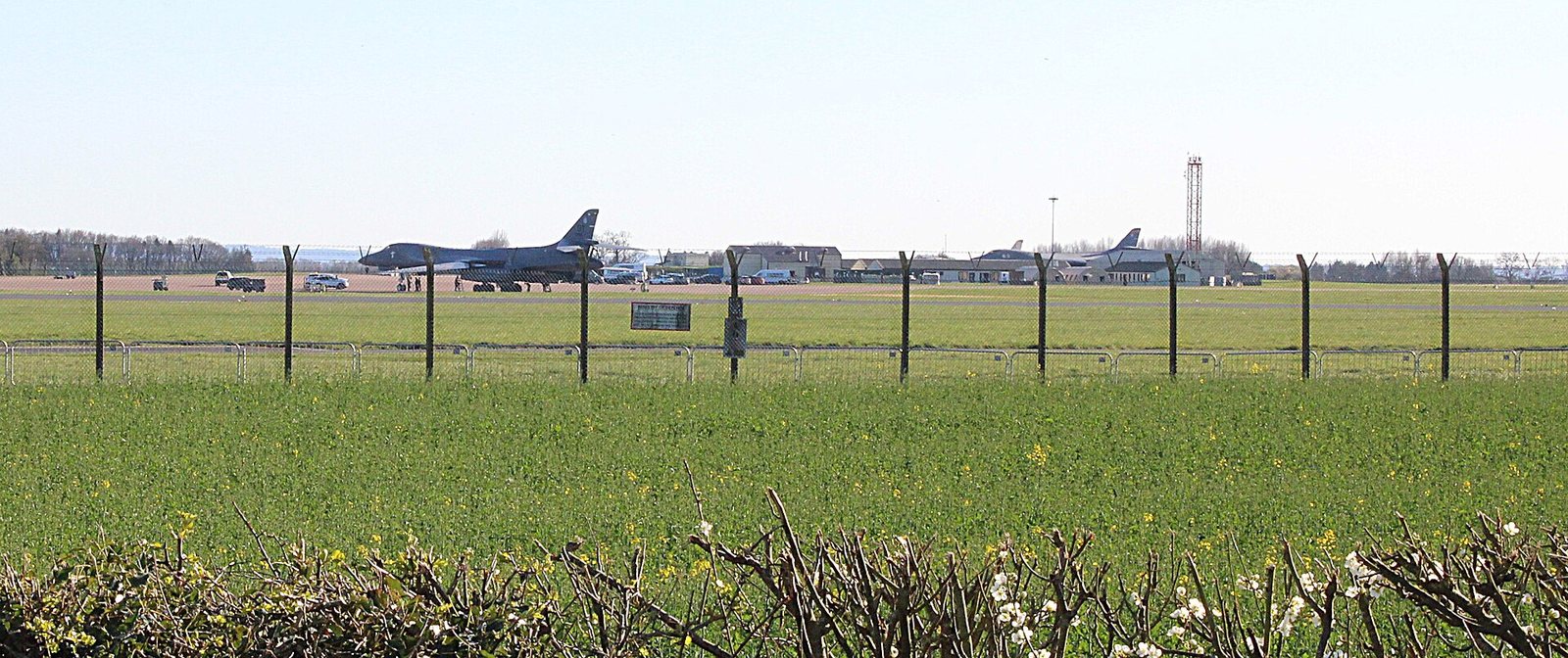 Military aircraft on the airfield at RAF Fairford, seen beyond the perimeter fence in March 2026 — illustrative